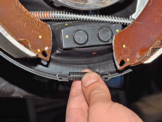 Снятие нижней пружины с тормозных колодок на заднем колесе Фольксваген Поло седан